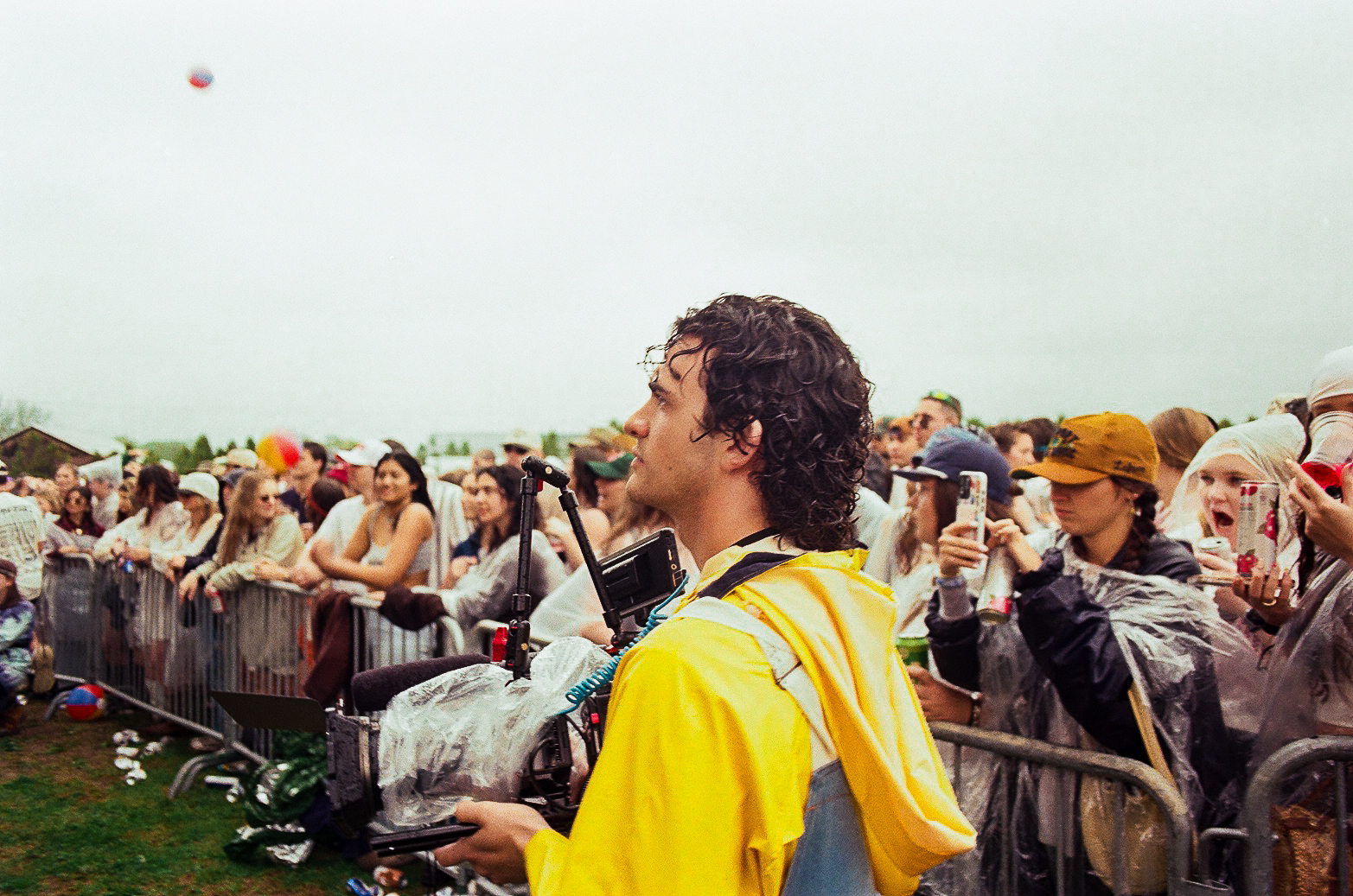 Salvi in a yellow rain poncho, holding a camera beside a concert crowd.